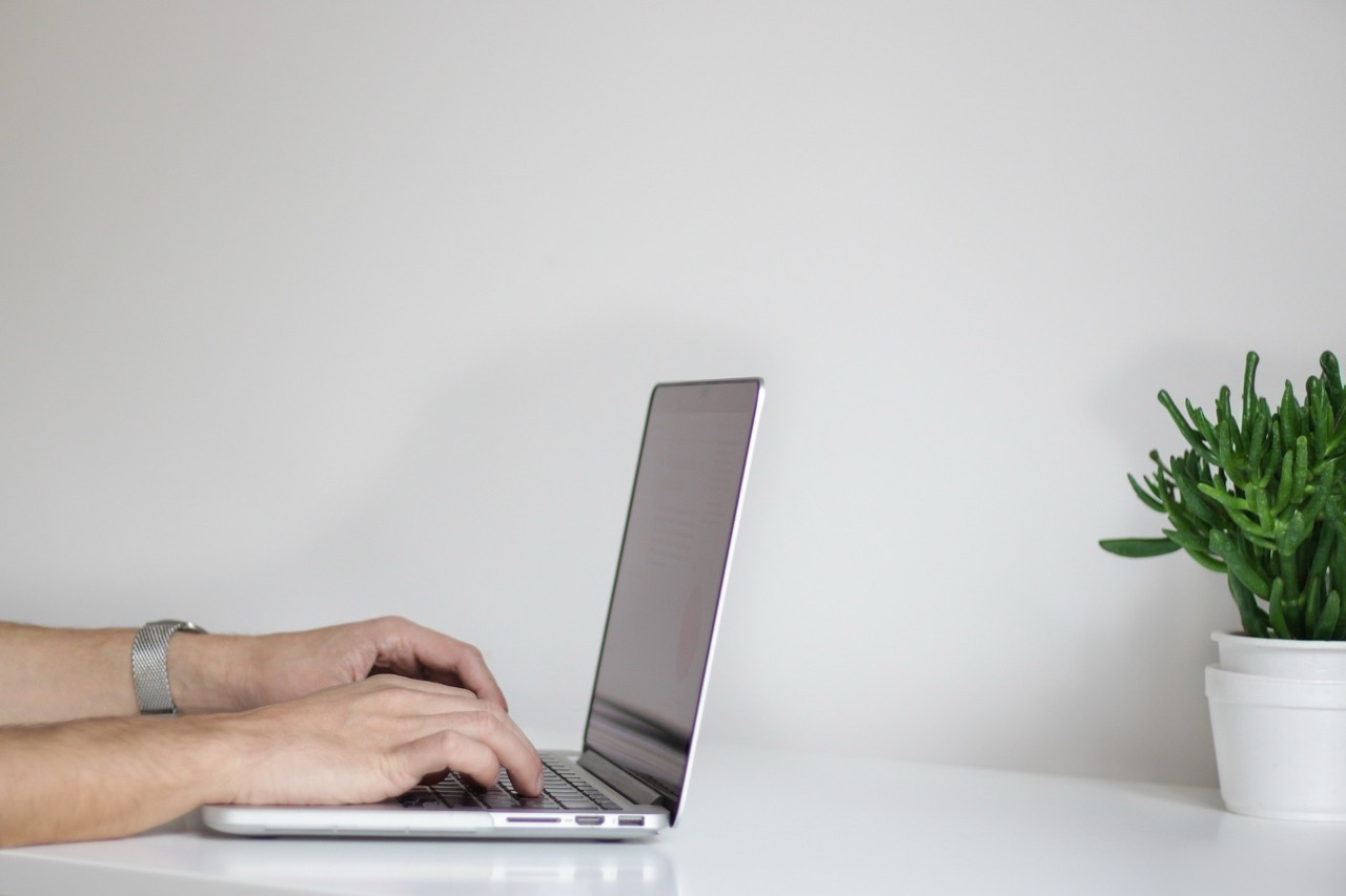 Two hands typing on a computer keyboard