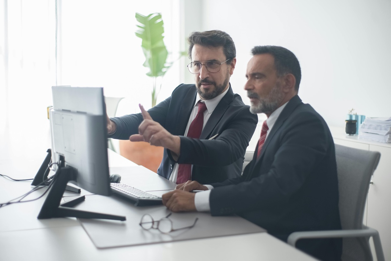 2 Men are discussing in front of a computer