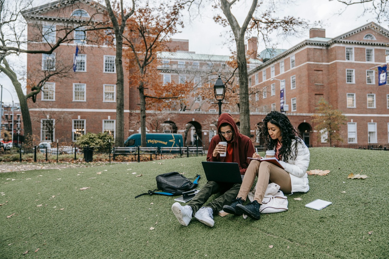 Two Students Having Online Lessons in a park