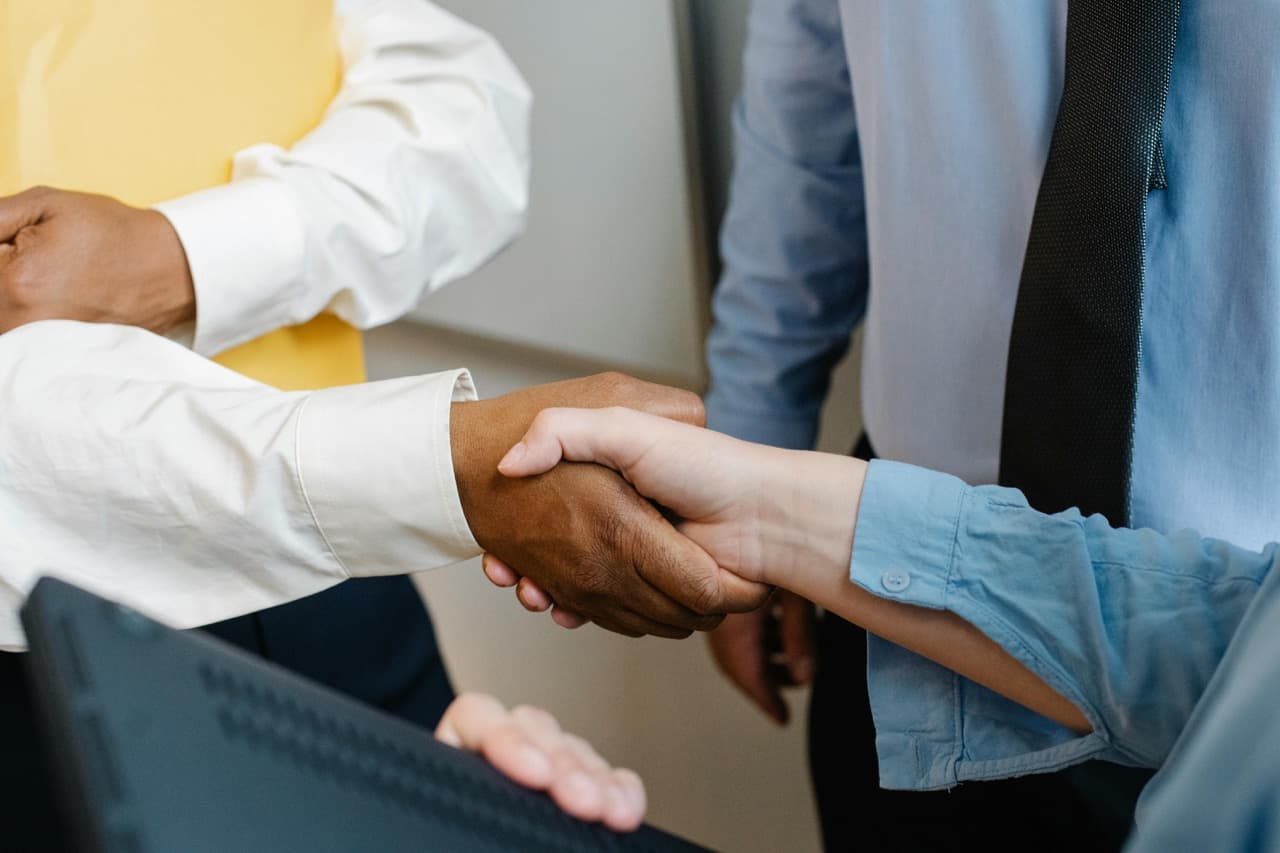 Two people shaking hands, representing a successful business partnership and company formation.